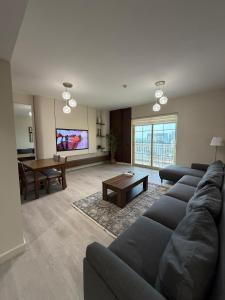 a living room with a couch and a table at شقة البيلسان فيو Baylasun View in King Abdullah Economic City