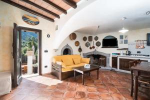 a living room with a yellow couch and a fireplace at Casa Bados in Dorgali