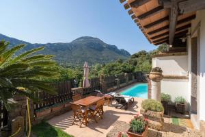 a patio with a table and chairs and a pool at Casa Bados in Dorgali