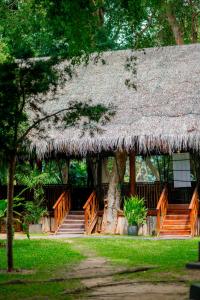 a hut with a thatched roof and stairs in a yard at Miridiya Lake Resort in Anuradhapura