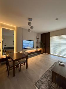 a living room with a table and a television at شقة البيلسان فيو Baylasun View in King Abdullah Economic City