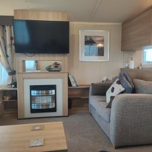 a living room with a couch and a fireplace at Our Retreat By The Waves in Bangor