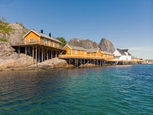 a row of houses on a dock on the water at Sakrisøy Rorbuer in Reine +163 photos