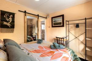a living room with a bed and a couch at Birdsong Cottage in Howick