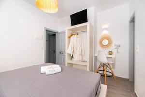 a white bedroom with a bed and a mirror at Kasteli Luxury Rooms in Perissa +43 photos