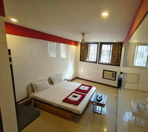 a small room with a bed and a table at Hotel Vishal - Near Surat Railway Station in Surat