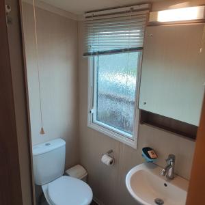 a small bathroom with a toilet and a sink at Our Retreat By The Waves in Bangor +58 photos