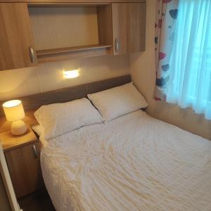a small bed in a small room with a window at Our Retreat By The Waves in Bangor