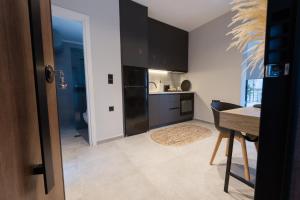 a kitchen with black cabinets and a table and a dining room at Loft 77 Patras in Patra