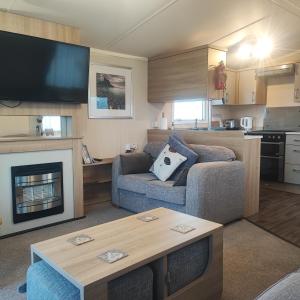 a living room with a couch and a fireplace at Our Retreat By The Waves in Bangor
