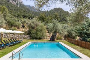 a swimming pool in a yard with chairs and trees at Honor - Rustic villa for 16 people in Bunyola