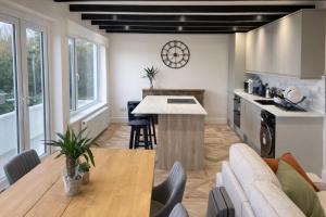 a kitchen and living room with a table and a couch at Valdermosa in Newlyn