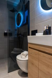 a bathroom with a toilet and a sink and a blue light at Loft 77 Patras in Patra +14 photos
