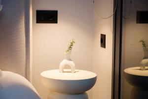 a white vase on a table in a room at Loft 77 Patras in Patra