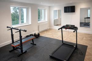 a gym with two tread machines and a flat screen tv at Valdermosa in Newlyn