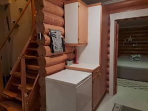 a small kitchen with a staircase in a log cabin at Kangasjärvi in Pudasjärvi