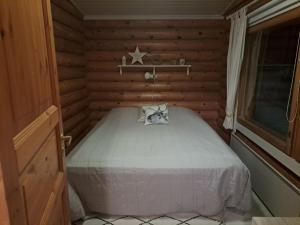 a small bedroom with a bed in a wooden room at Kangasjärvi in Pudasjärvi