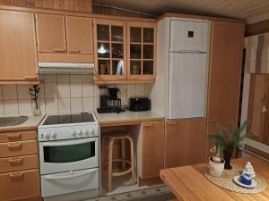 a kitchen with a white stove and a refrigerator at Kangasjärvi in Pudasjärvi