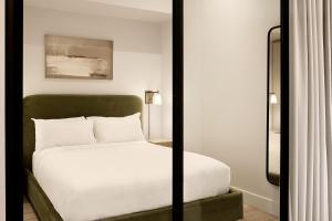a bedroom with a bed and a mirror at Eurostars Old Montreal Suites & Apartments in Montreal
