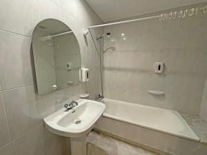 a bathroom with a sink and a tub and a mirror at Hotel Acquamaris 3000 in Sanxenxo