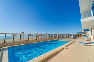 a swimming pool with the ocean in the background at Hotel Marian Platja in Roses