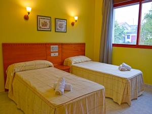 two beds in a room with yellow walls at Hotel Acquamaris 3000 in Sanxenxo +74 photos