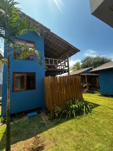 a blue house with a fence in a yard at Vila Saquaira in Marau