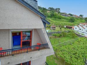 a balcony of a house with red chairs on it at Hotel Acquamaris 3000 in Sanxenxo