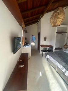 a room with a bed and a tv and a table at Vila Saquaira in Marau