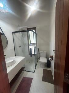 a bathroom with a sink and a toilet and a mirror at Vila Saquaira in Marau +60 photos