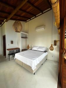 a bedroom with a large bed and a desk at Vila Saquaira in Marau