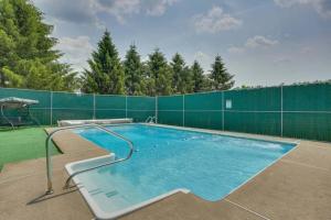 a large swimming pool with a green fence at Wander & Unwind Log Cabin And Suites At Equestrian House in Pleasant Mount