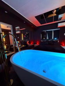 a large blue tub in a room with a bed at Ama Suite Romantic Spa in Bologna