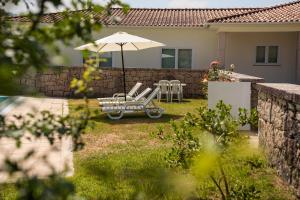 a couple of chairs and an umbrella in a yard at Casa Panorâmica Aurora in Celorico de Basto