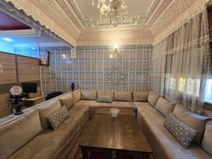 a living room with a large couch and a chandelier at Hostel El Raha in Fez