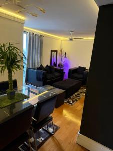 a living room with a glass table and black furniture at Quartos Vila Augusta/Guarulhos in Guarulhos