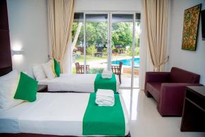 a hotel room with two beds and a couch at Miridiya Lake Resort in Anuradhapura +38 photos