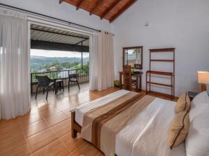 a bedroom with a large bed and a balcony at Swarga Villa in Kandy