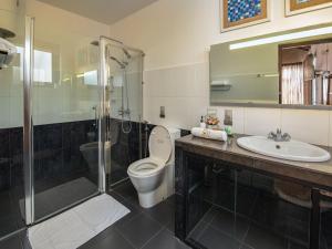 a bathroom with a toilet and a shower and a sink at Swarga Villa in Kandy