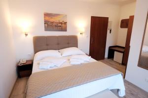 a bedroom with a bed with towels on it at Hotel Vila Tina in Trogir +37 photos