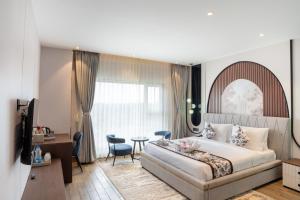 a bedroom with a bed and a table and chairs at Trinity Hotel Banquet & Spa in Siliguri
