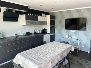 a kitchen with a table and a sink and a tv at Wellness Apartment Ilse - Apartment mit eigenem Spa in Thaur