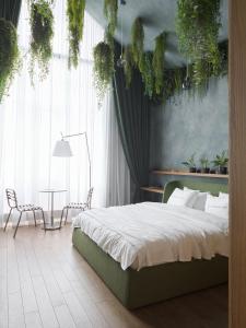 a bedroom with a bed and a table and plants at Lesi City Guide Hotel in Kyiv