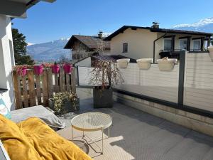 a patio with a table and a chair on a balcony at Wellness Apartment Ilse - Apartment mit eigenem Spa in Thaur