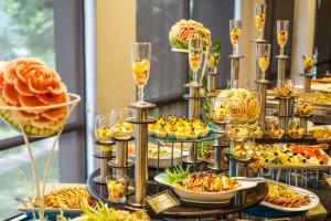 a buffet with many plates of food and drinks at Rose Lagoon Hotel in Vakarai