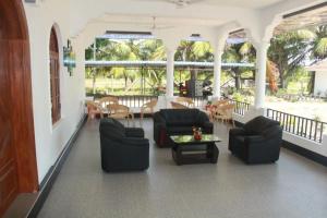 a living room with chairs and a table at Rose Lagoon Hotel in Vakarai