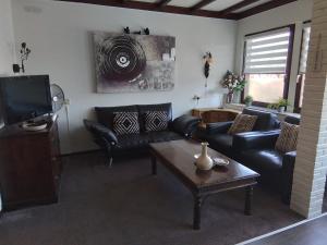 a living room with leather couches and a tv at D'n Engel in Sittard