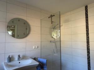 a bathroom with a sink and a shower with a mirror at Ferienhaus Pirat Störtebeker Dangast in Dangast +76 photos