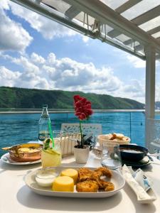 a plate of food on a table with a view of the water at Riviera 990 - Resort & Restaurant in Eşelniţa