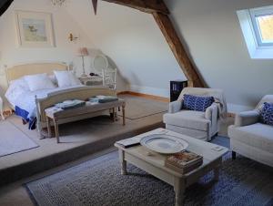 a living room with a bed and two chairs and a table at Le Presbytere in Beauficel